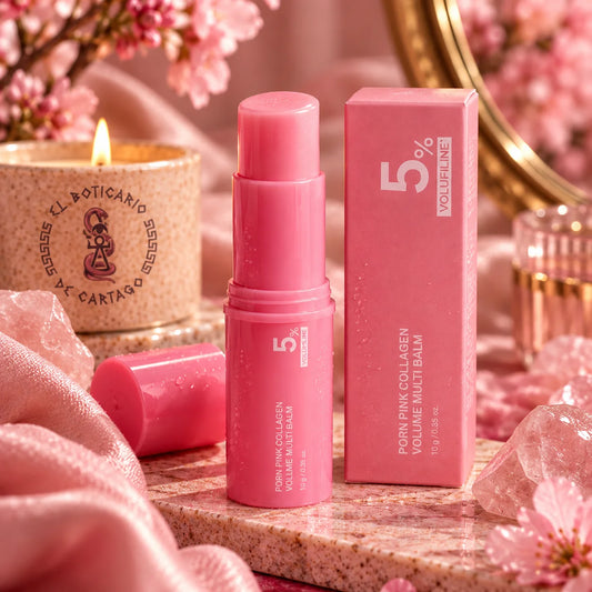 Bálsamo iluminador en stick con PDRN de El Boticario de Cartago, en tono rosa, junto a su caja y una vela encendida