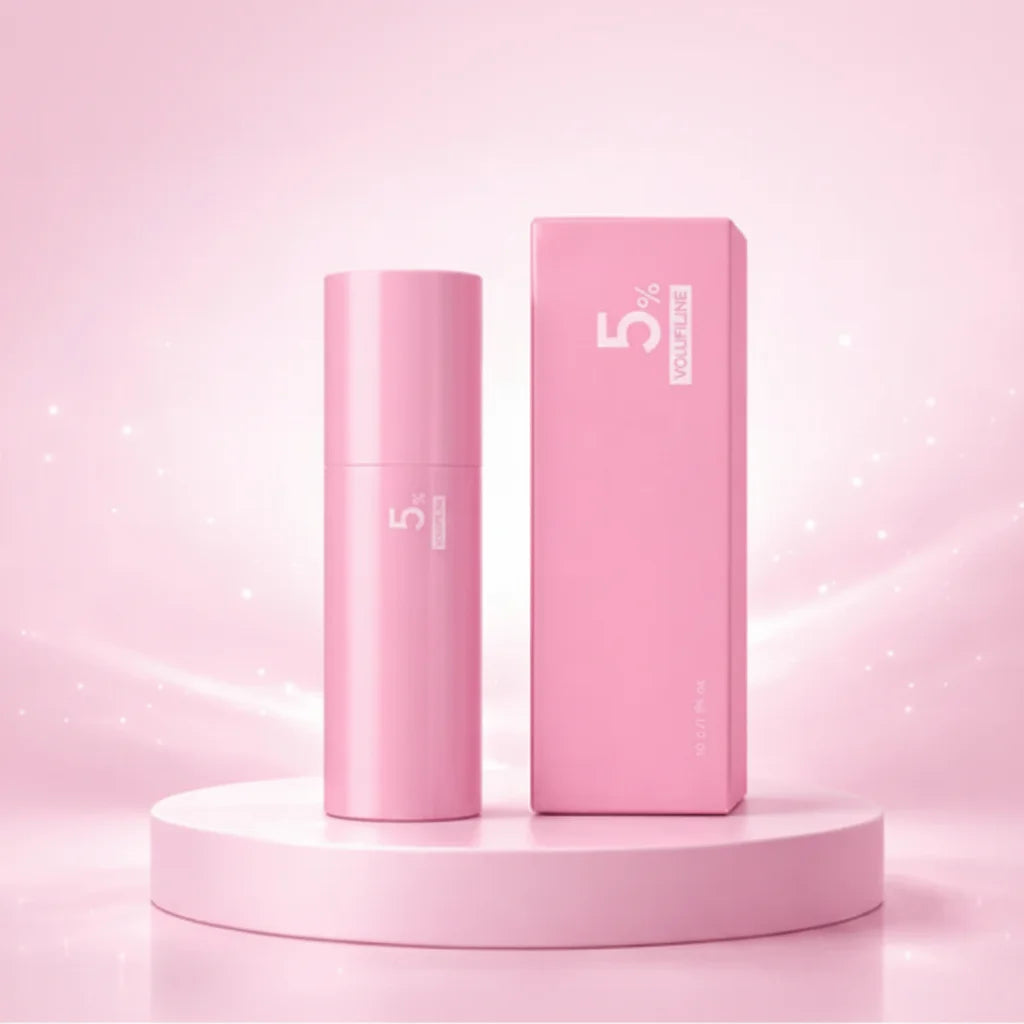 Bálsamo stick PDRN y Colágeno 200 Dalton con 5% Volufilina sobre podio blanco, fondo rosa suave