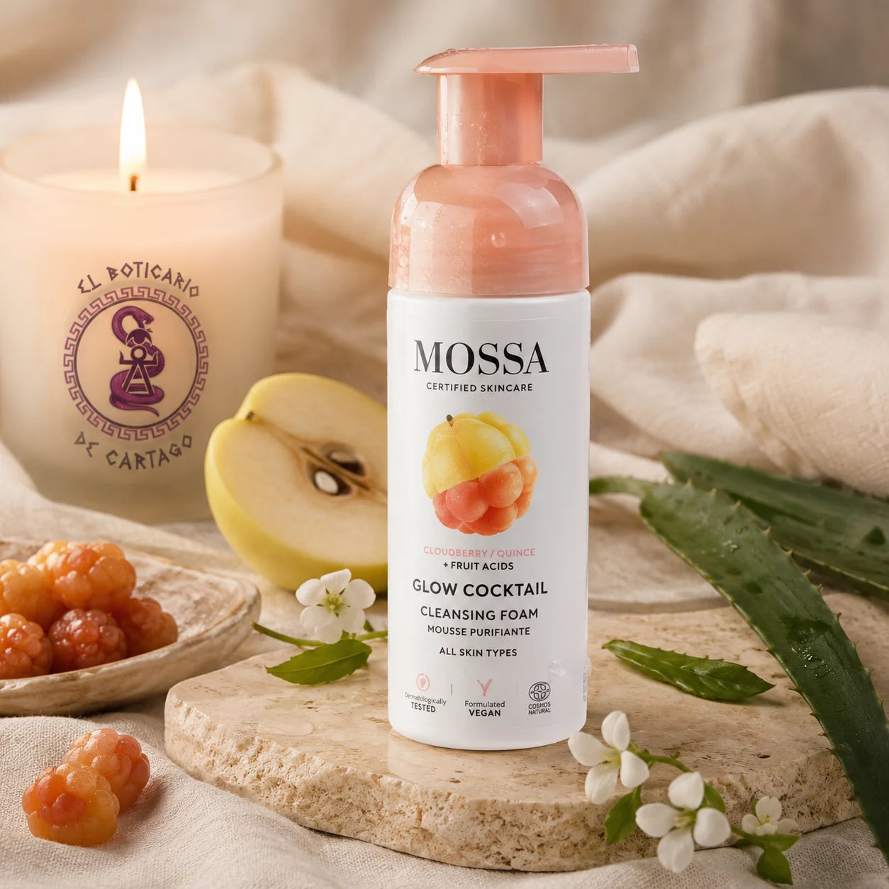 Espuma limpiadora facial MOSSA Glow Cocktail sobre fondo de lino con aloe vera, cloudberry, membrillo y vela decorativa en ambiente spa premium.